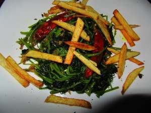 Stir fried fenugreek leaves topped with crispy potato strips