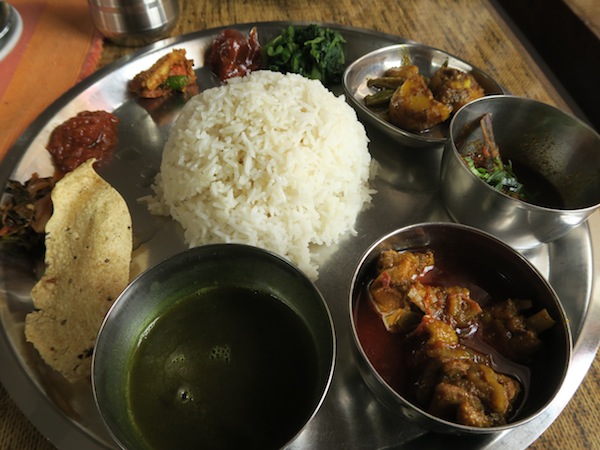 Thakali Khana set- Rice, Black lentil daal, Chicken curry, Fish curry, Seasonal vegetable curry, Stir-fried spinach, Radish pickle, Timur-Tomato chutney, Lapsi pickle, Gundruk pickle and Papad